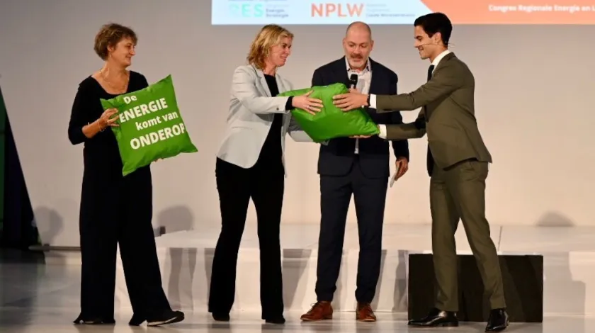 Rob Jetten, minister voor Klimaat en Energie ontvangt van directeuren Kristel Lammers (NP RES) en Maureen van Eijk (NPLW) twee warmtekussens met de opdruk ‘De energie komt van onderop’: voor hemzelf en collegaminister Hugo de Jonge