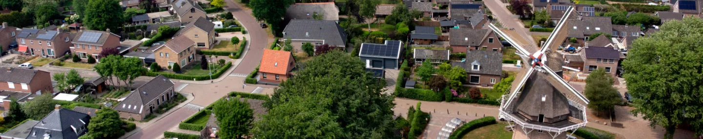 Luchtopname van het dorp Dalen met huizen tussen het groen, rechts de molen Jan Pol en in de verte landerijen