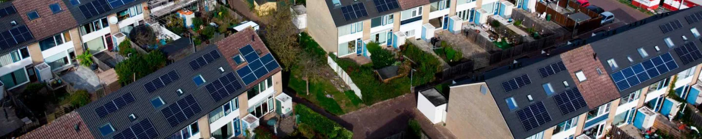 Luchtopname van jaren '60 en '70 rijtjeshuizen met zonnepanelen op de daken