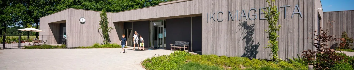 Modern houten schoolgebouw met schoolplein ervoor